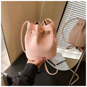 Close-up of pink bucket bag with snake skin pattern and gold twist lock detail
