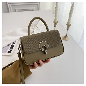 Detail of olive green handbag with woven texture flap and silver ring metal lock