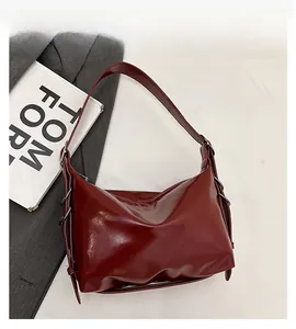 Detail shot of a wine red Hobo tote bag showing polished faux leather and metal rings