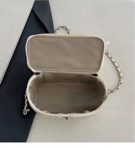 Top view of cream-white chain bag showing brown herringbone lining and interior space