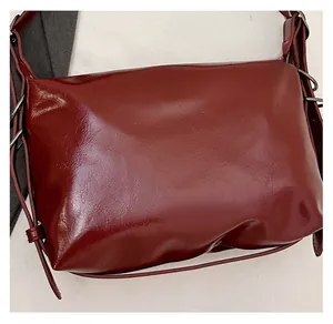 Detail of wine red tote bag showing glossy lychee texture and silver metal rings