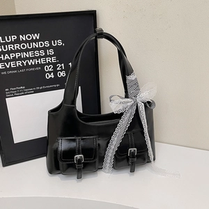 Chic black leather shoulder bag with large lace bow accent and dual front pockets