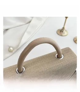 Detail of minimalist beige handbag showing waffle texture fabric and silver metal rings