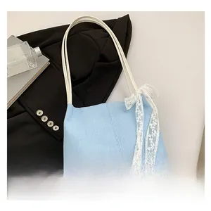 Detailed close-up of light blue canvas tote bag with a white lace bow and PU straps