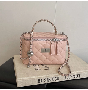 Detail of pink quilted leather mini bag with silver chain strap and metal ball charm
