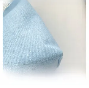 Close-up of light blue canvas bag fabric with delicate white lace edge detailing