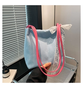 Close-up of light blue denim tote with pink straps and white lace ribbon detail