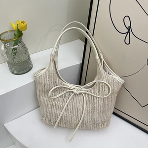 Chic straw hobo bag with large leather bow detail for summer commute or beach vacation