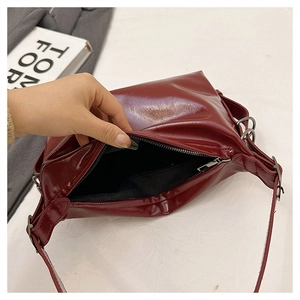 Detail view of dark red glossy tote bag interior with zipper and fabric lining