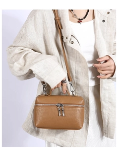Detailed view of brown lychee grain leather crossbody bag with dual zipper closure