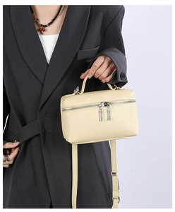Detail of cream leather mini square bag with silver double zippers and litchi texture