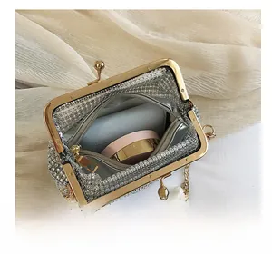 Detail showing spacious interior of a silver rhinestone clutch bag with gold metal frame