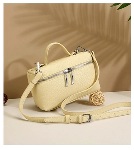 Detailed shot of beige lychee grain leather handbag with silver hardware and top handle