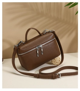 Macro shot of brown pebble grain leather texture and metallic zipper on a retro handbag