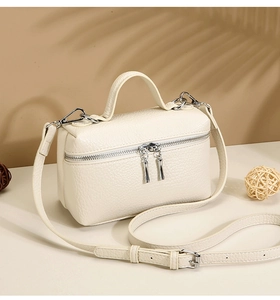 Detail of cream white lychee texture leather handbag with silver hardware and top handle