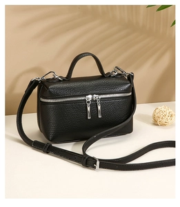 Close-up of black lychee grain leather mini bag with silver double zipper and top handle