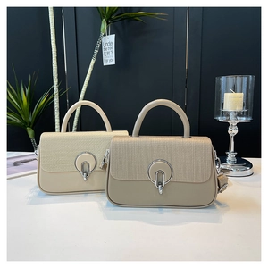 Detail of woven texture flap and round silver buckle on beige crossbody handbags