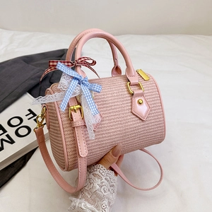 Sac cylindrique tissé rose avec nœud à carreaux et dentelle sur tissu blanc