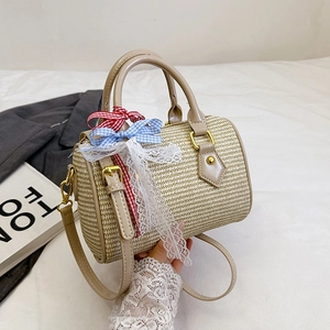 Sac à main cylindrique en paille tressée avec poignées en cuir et nœuds décoratifs