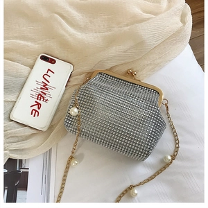 Detail of silver rhinestone evening clutch with gold metal frame and pearl chain