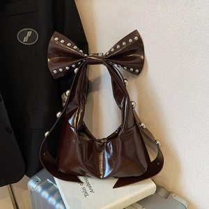 Retro dark brown patent leather shoulder bag with large rivet bow and silver stud details