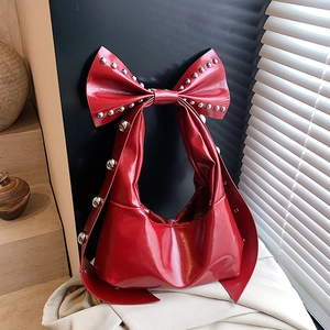 Retro red patent leather hobo bag featuring giant bow and silver rivet studs
