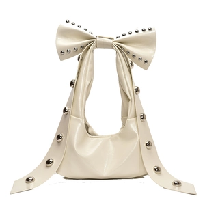 Chic cream leather underarm bag featuring a large bow handle and silver stud accents