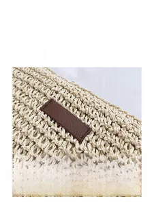 Detailed close-up of woven straw texture with a brown leather patch on a bucket bag