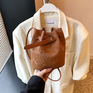 Brown snakeskin textured mini bucket bag with gold turn-lock and slim shoulder strap