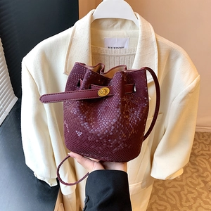 Chic burgundy bucket bag with snake skin texture and gold hardware for daily outfit