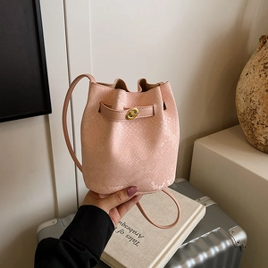 Pink snakeskin embossed mini bucket bag with gold lock and slender shoulder strap
