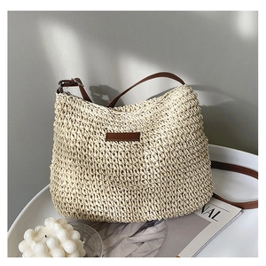 Detailed close-up of cream straw bucket bag texture with brown faux leather strap