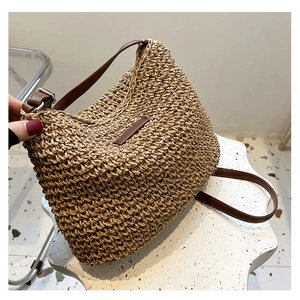 Detail of hand-woven straw texture and brown leather strap with silver metal buckle
