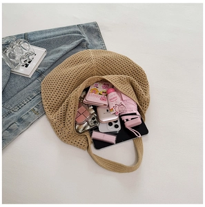 Flat lay of hollow mesh straw bag showing large capacity for iPad, umbrella and wallet
