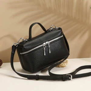 Minimalist black pebble leather crossbody handbag with silver zipper and top handle
