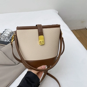 Chic two-tone canvas bucket bag with brown leather trim and golden twist lock closure