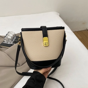 Chic beige woven bucket bag with black leather trim and gold twist lock for women