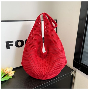 Close-up of vibrant red crochet beach bag featuring intricate hollow out knit patterns