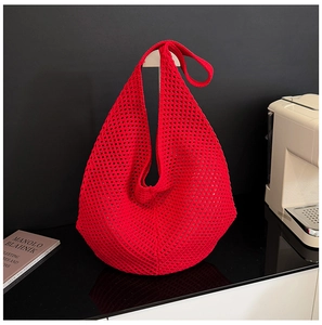 Detail of red hollow knit hobo bag showing large capacity and woven mesh texture