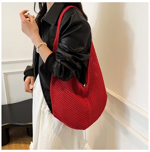 Red knit hollow tote bag style on model with a black leather jacket and white skirt