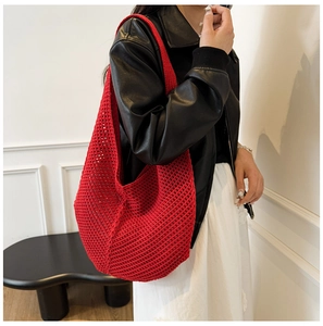 Detail of red hollow-out knitted hobo bag showing texture and high-capacity mesh design