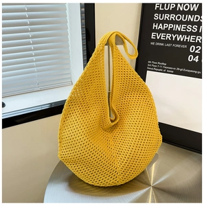 Detail view of bright yellow crochet knit tote bag with breathable hollow-out pattern design