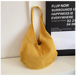 Detail of yellow crochet beach bag showing handmade mesh texture and cotton weave