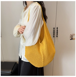 Detail of yellow knit crochet beach hobo bag with a distinctive hollow grid pattern