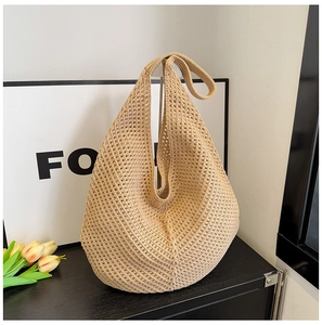 Detailed texture of beige hollow woven hobo bag with a minimalist integrated wide shoulder strap