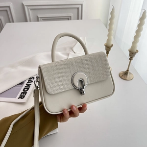 Minimalist beige crossbody bag with textured flap and silver round buckle hand-held