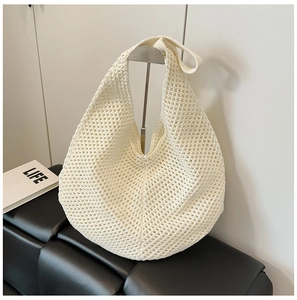 Detailed close-up of cream knit shoulder bag featuring hollow mesh and textured weave
