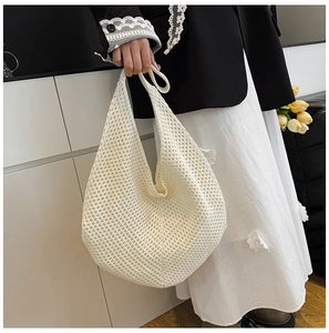 Close-up of a white crochet knit tote bag showing intricate mesh texture and woven detail