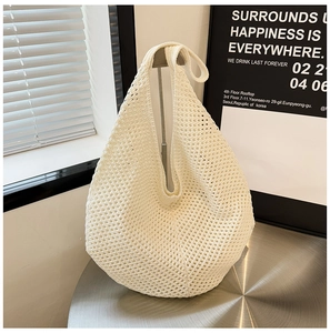 Detail of a beige crochet tote bag with intricate mesh weave pattern and hollow design