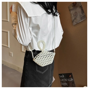 Detail of handmade pearl woven bag featuring a round handle and long crossbody strap
